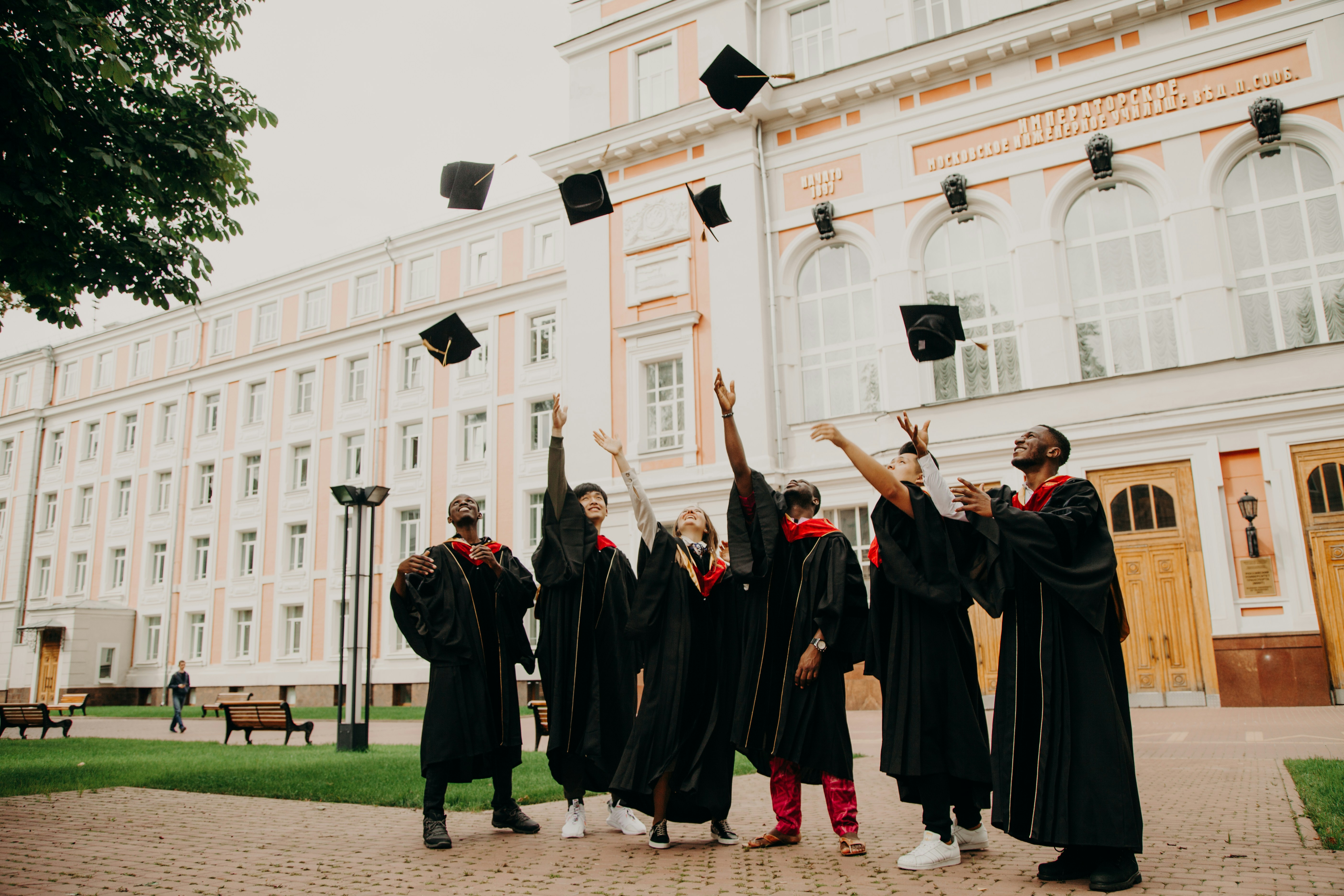 University graduates throwing their caps in the air — the kind of milestone a stable financial footing makes possible